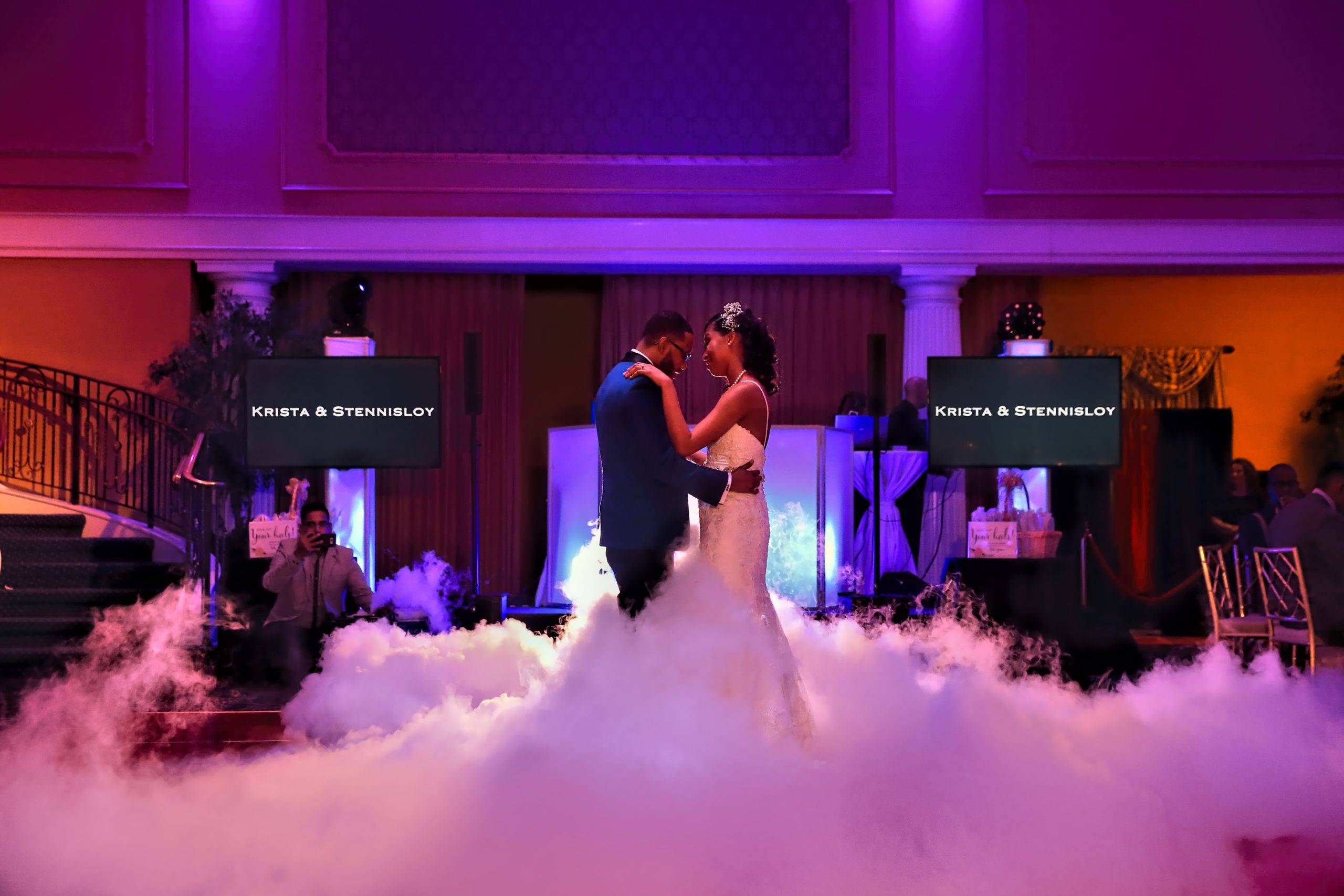 A bride and groom dancing in a cloud of smoke.
