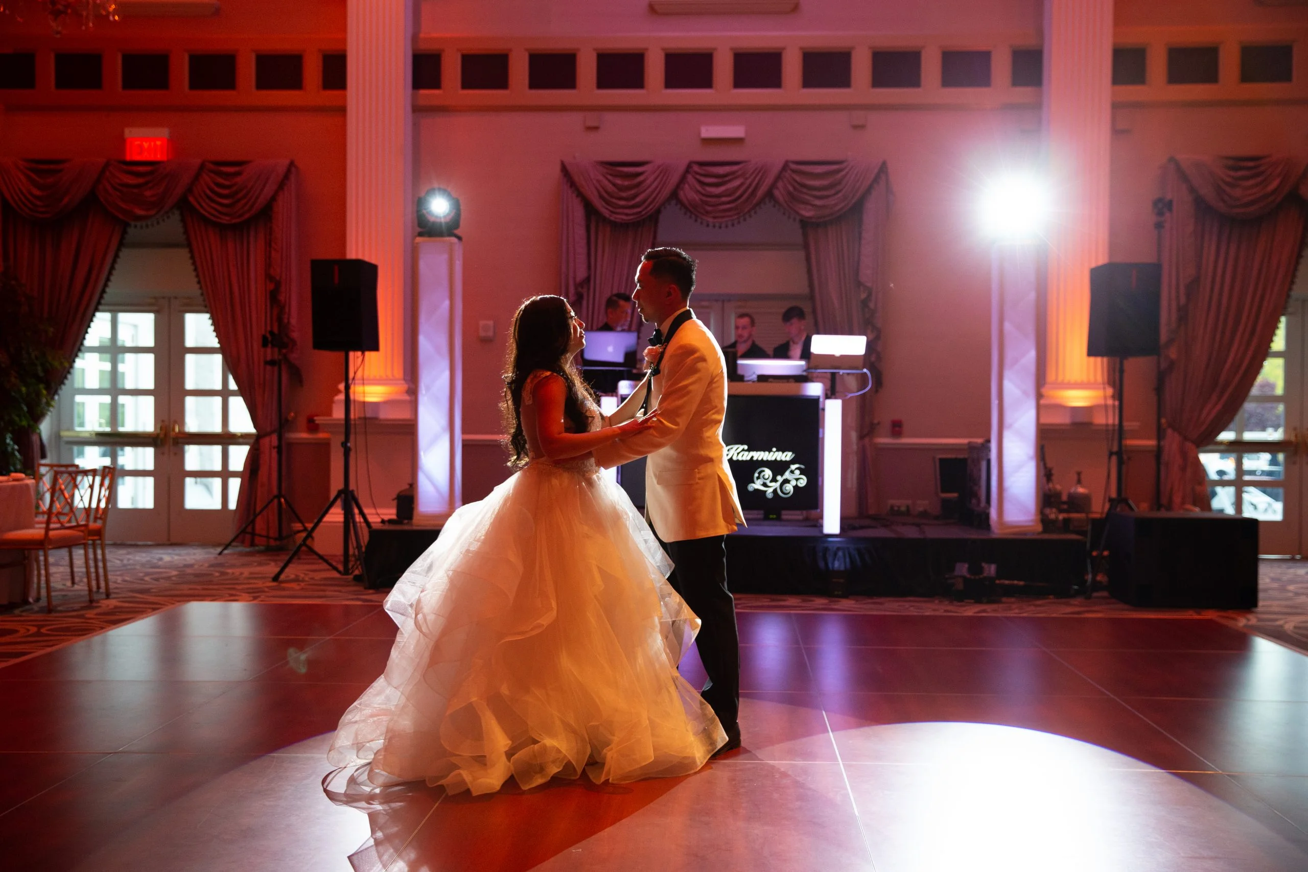 A bride and groom sharing their first dance in a ballroom.