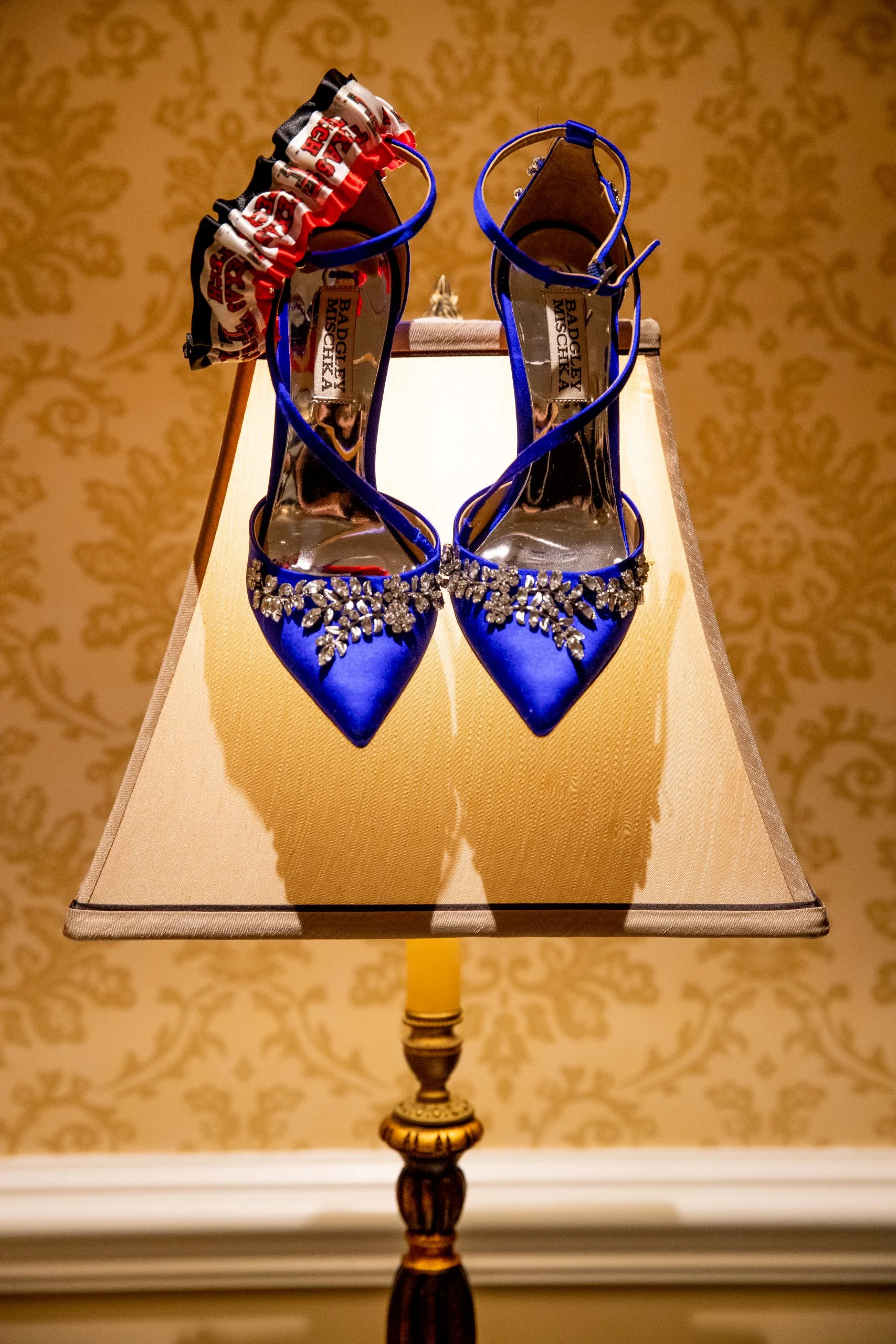 A pair of blue high heeled shoes on a lamp.
