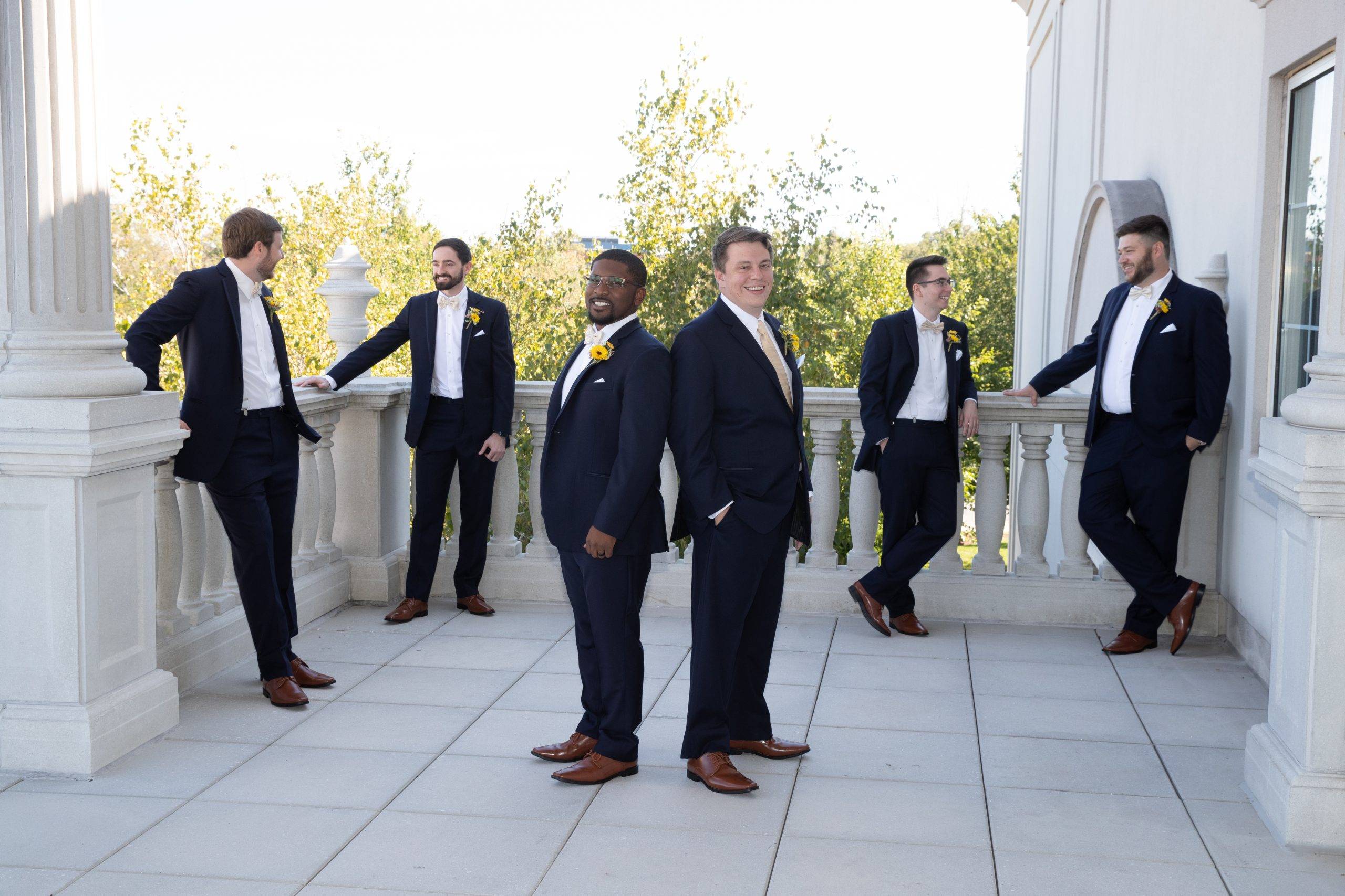 A group of groomsmen standing on a balcony.