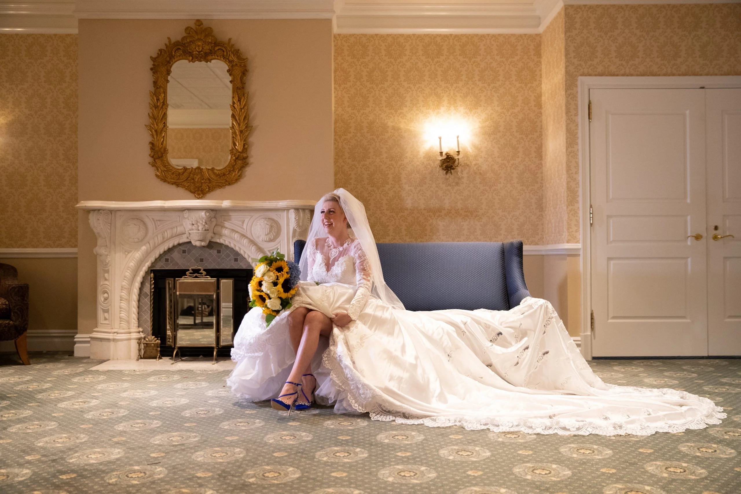 A bride in a wedding dress sitting on a couch in a room.