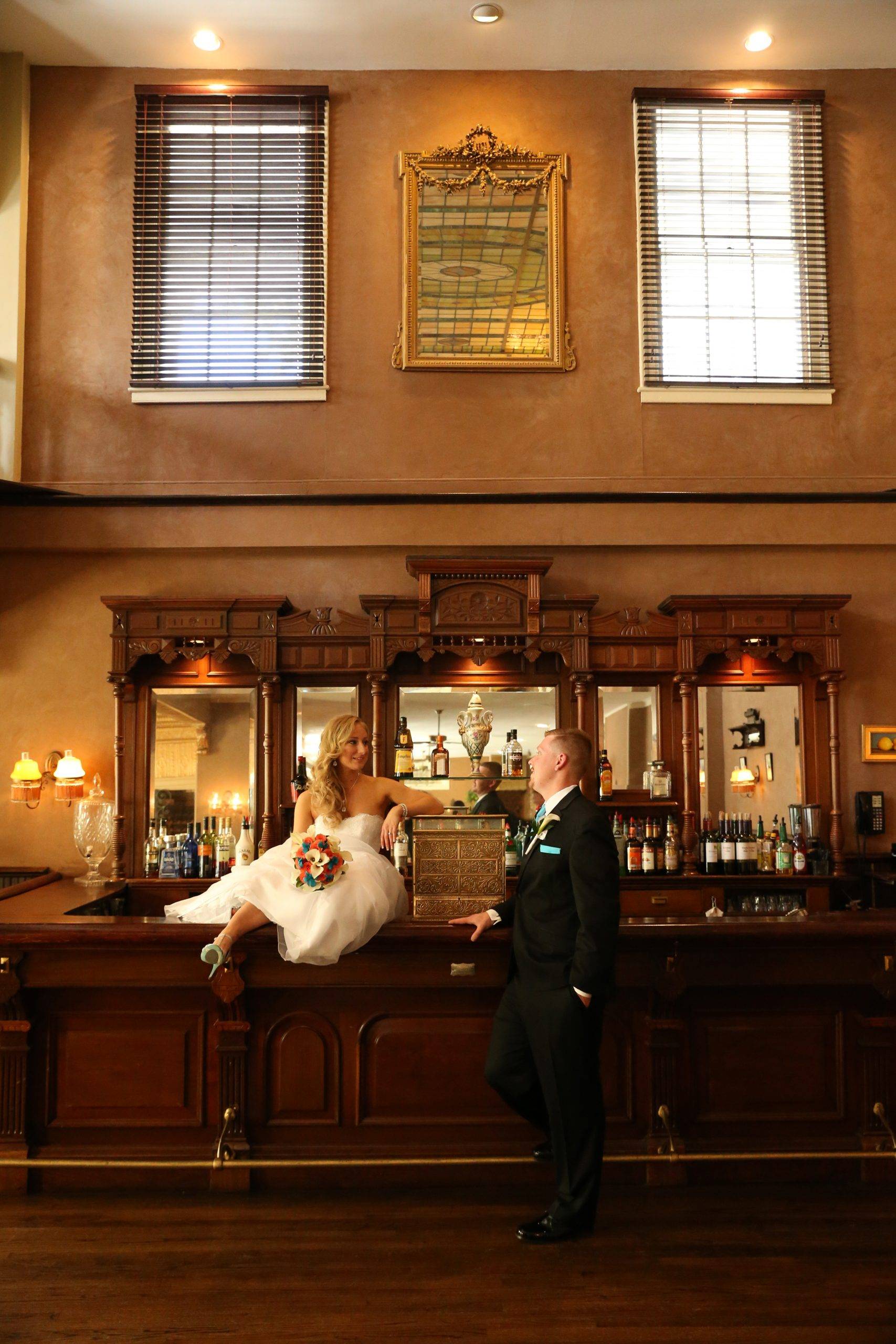 A bride and groom posing at a bar.