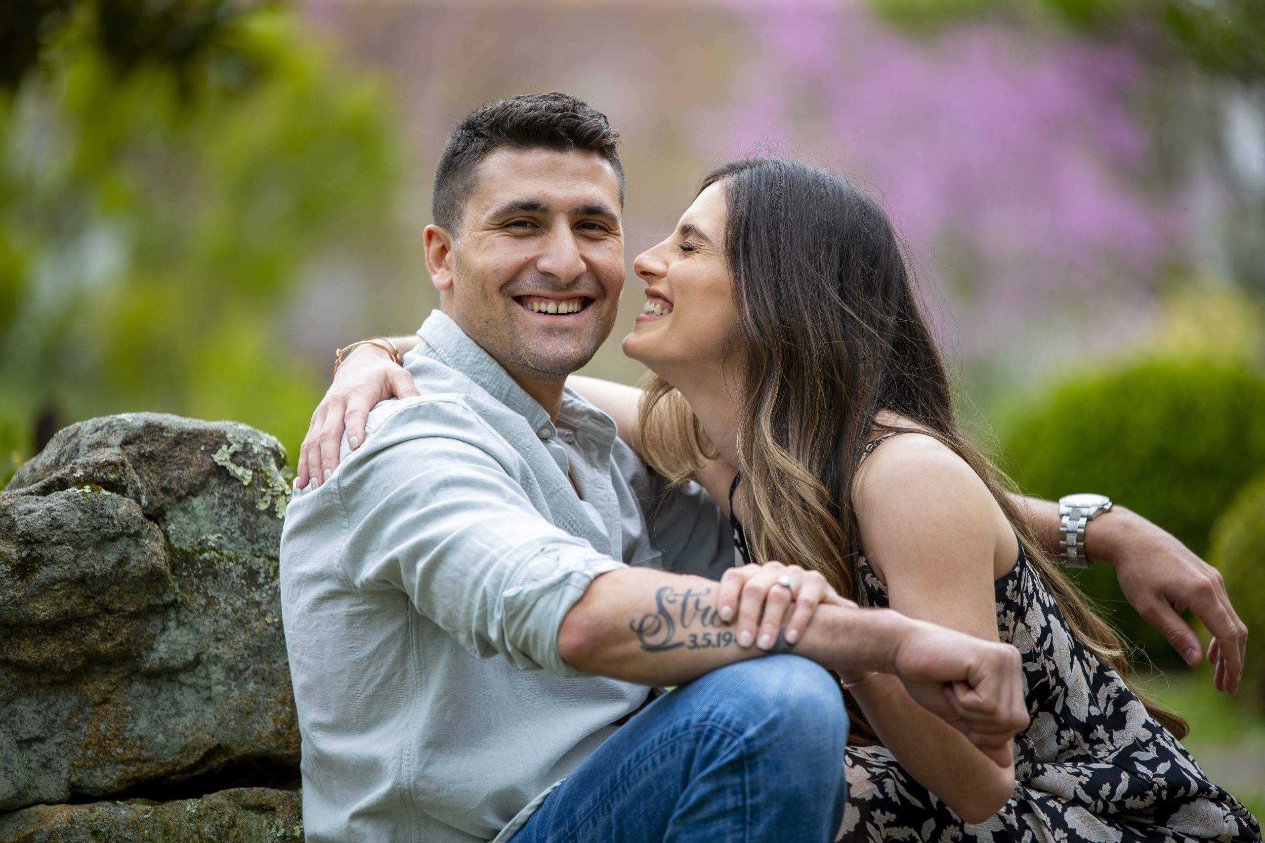 A couple is posing for an engagement photo in a park.