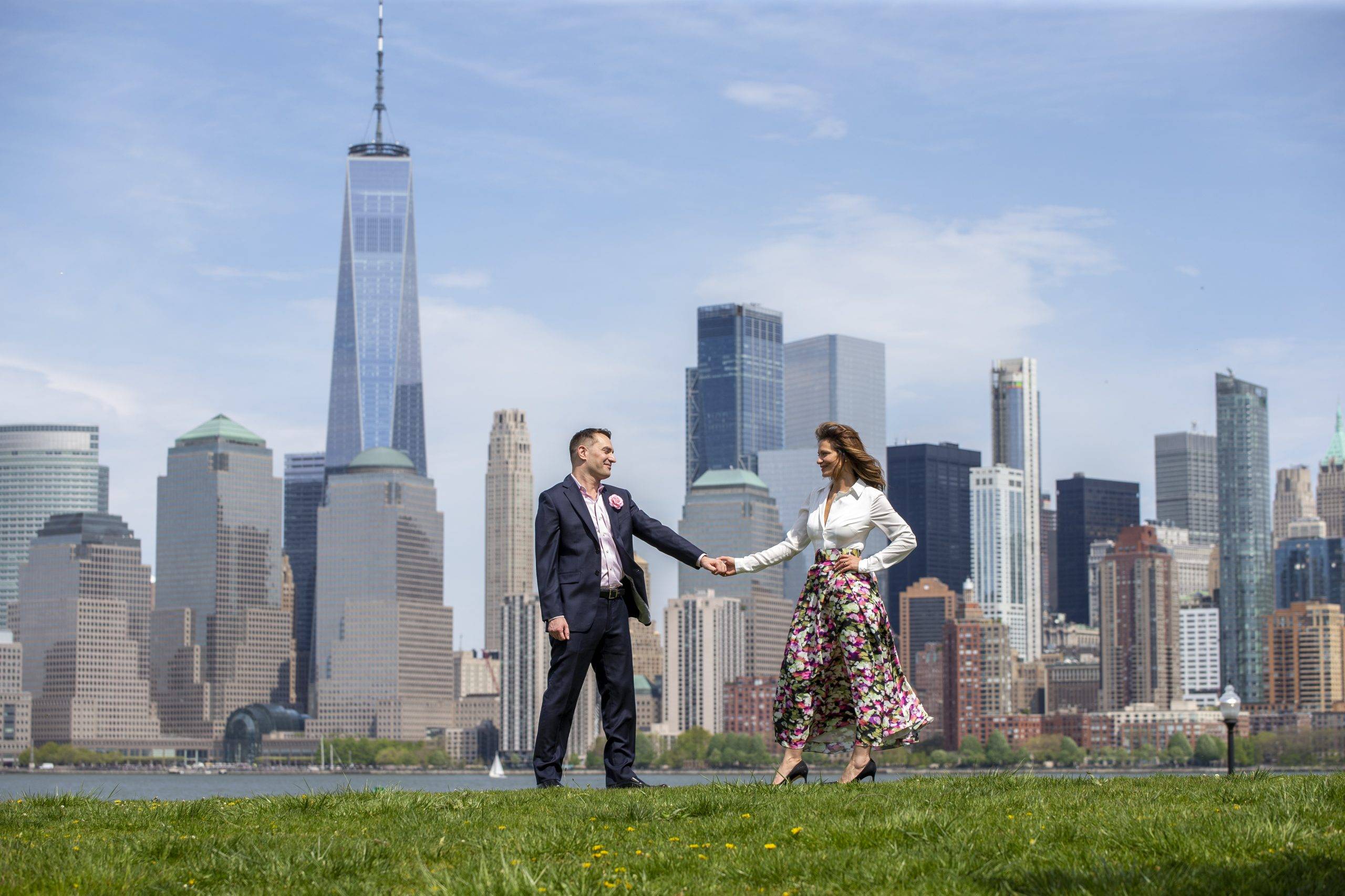 A man and woman holding hands in front of a city skyline.
