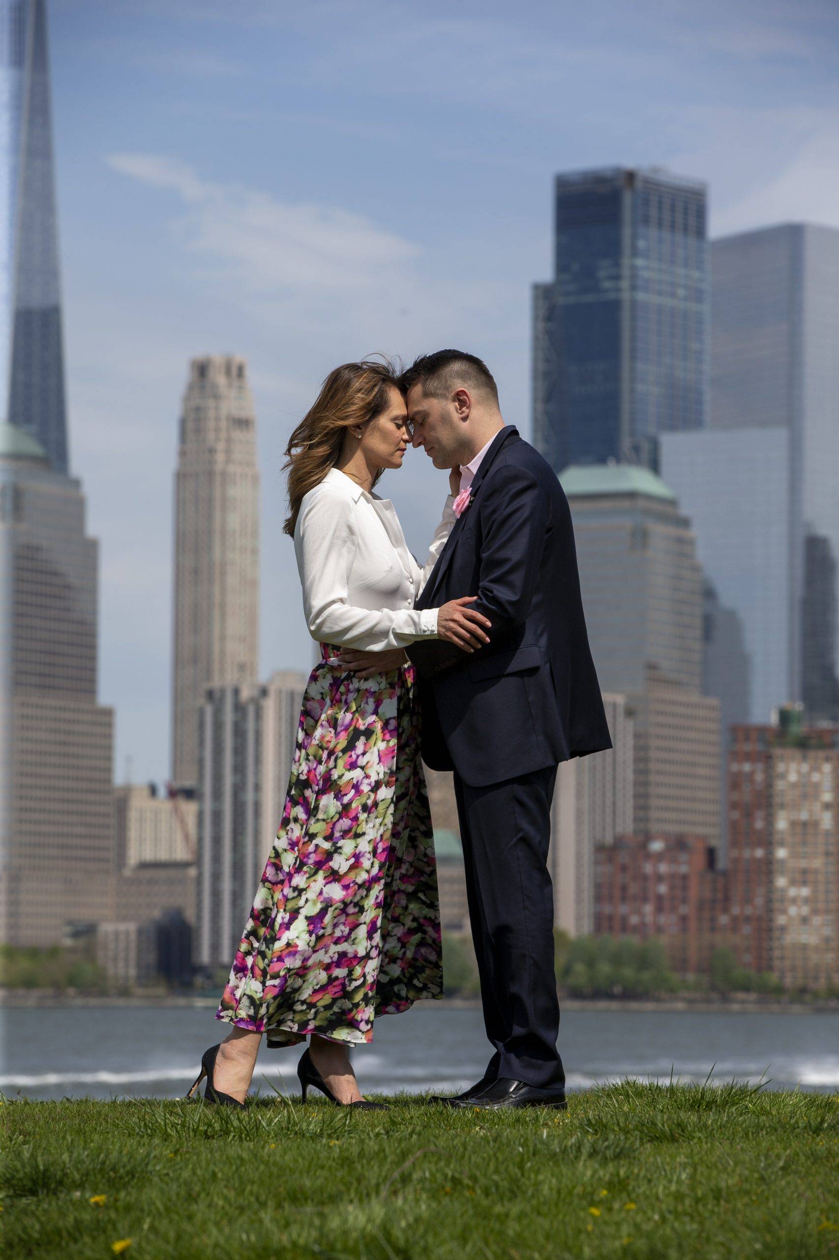 A couple embracing in front of a city skyline.