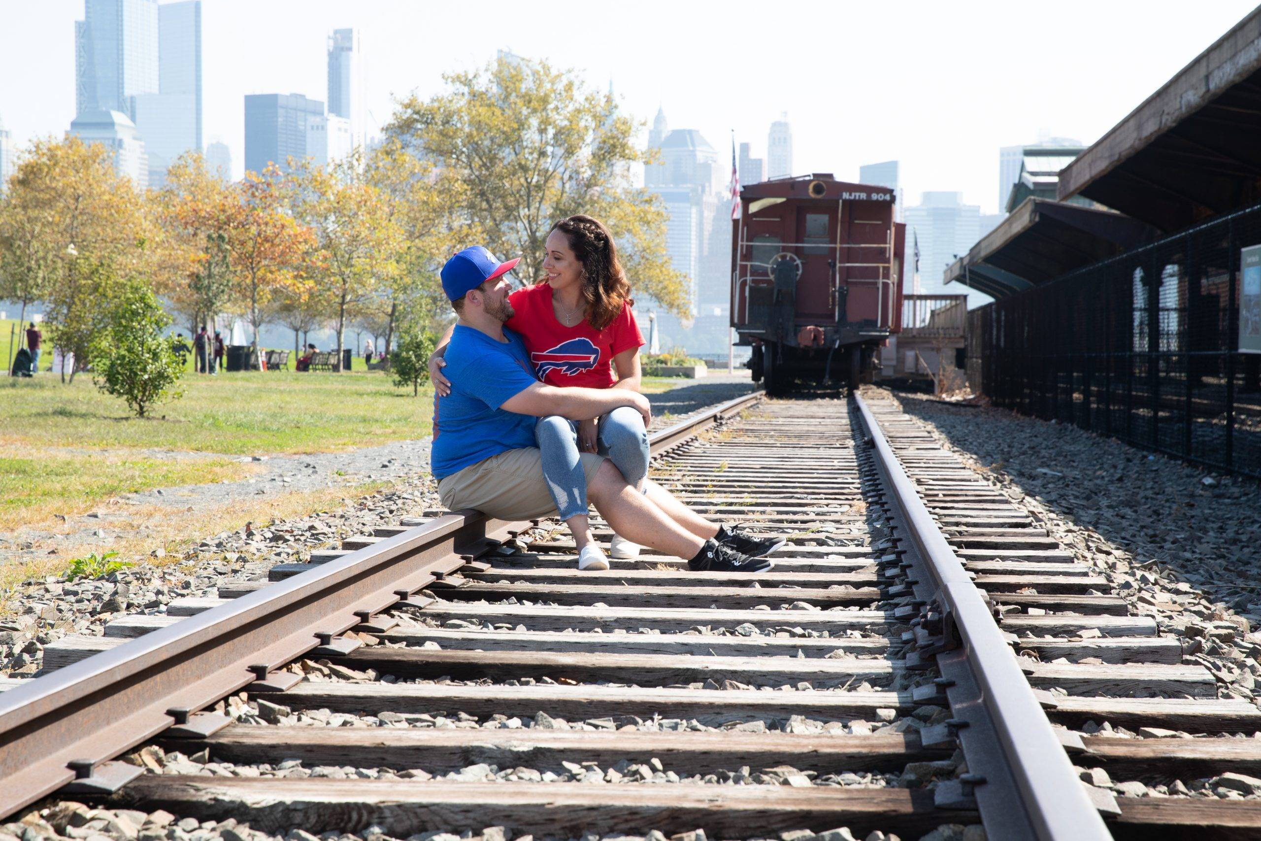 A man and woman sitting on train tracks.
