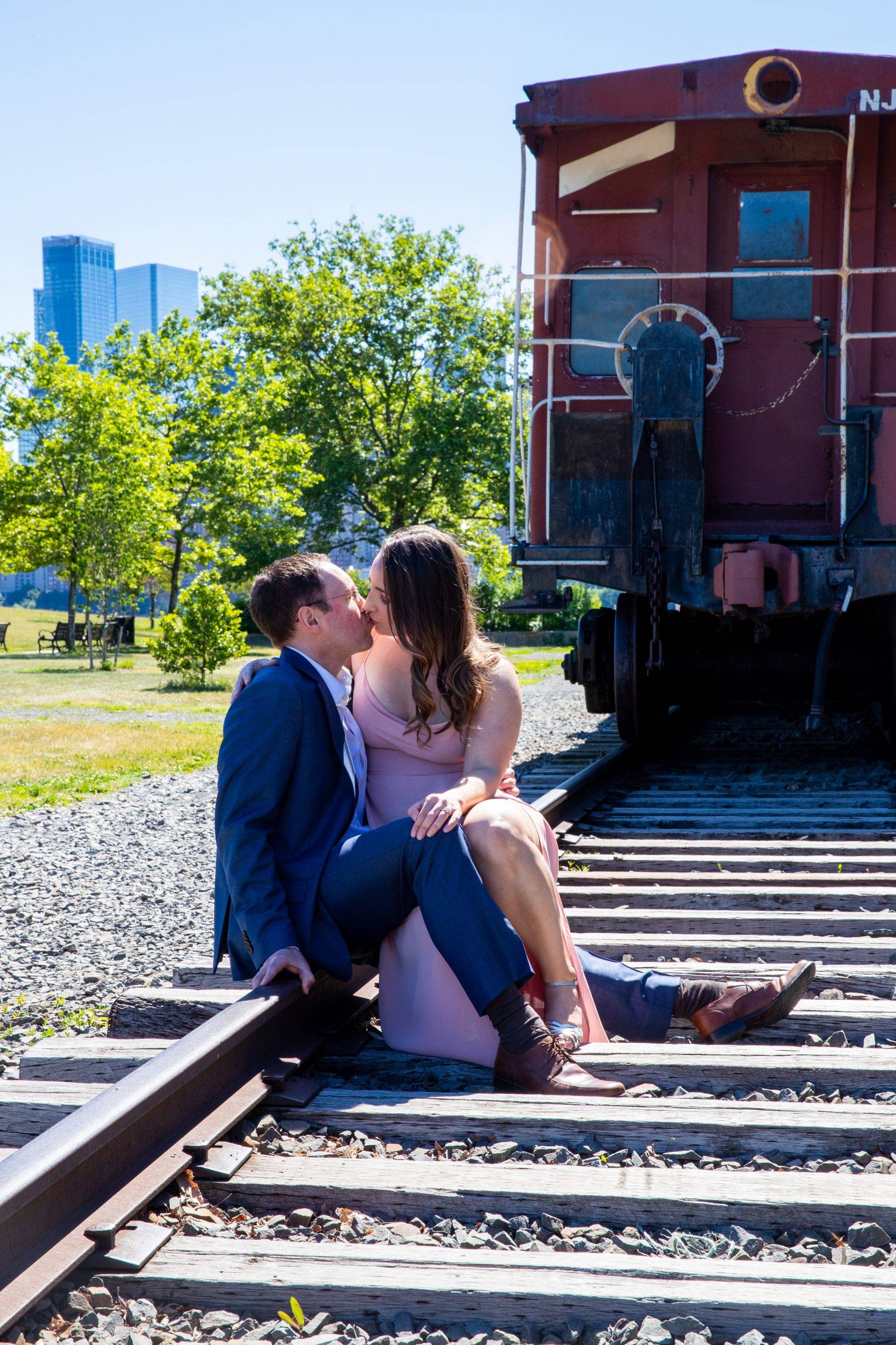 A couple kissing on the train tracks.