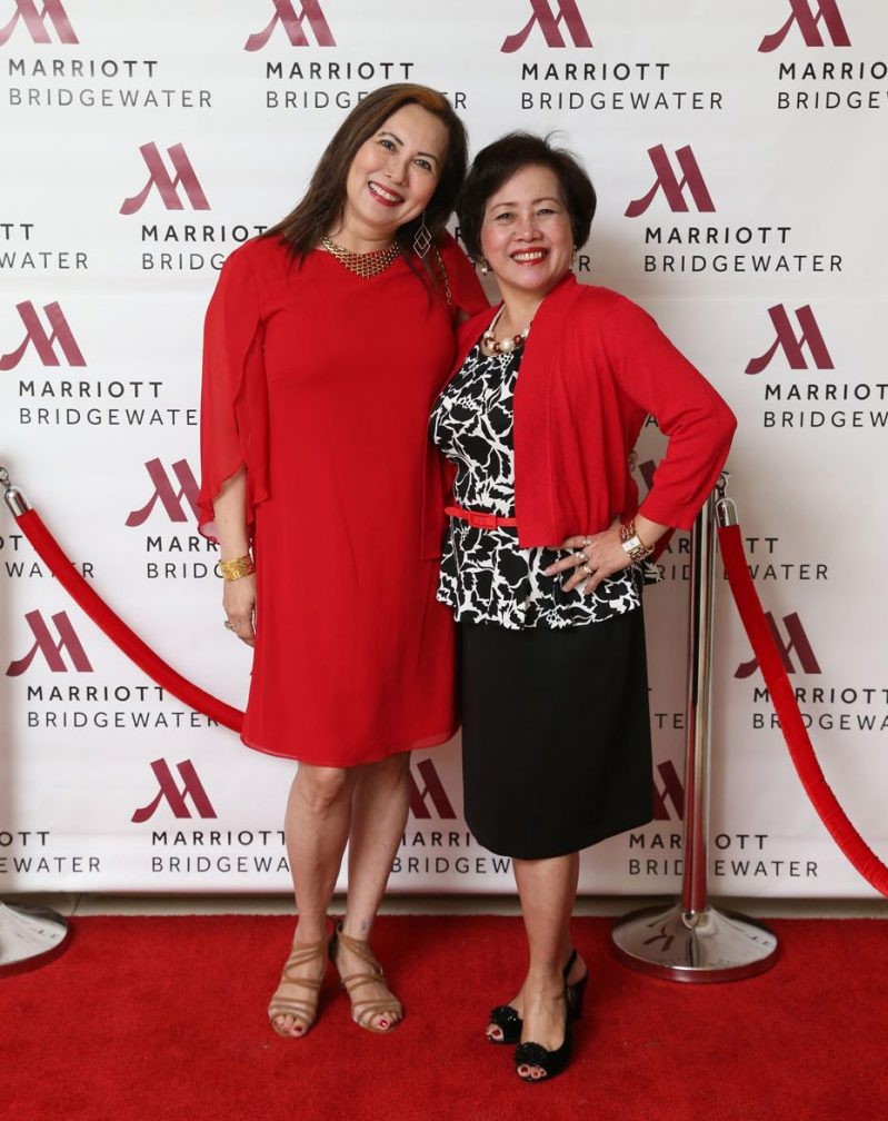 Two women posing for a photo on a red carpet.